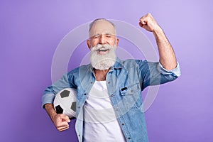 Photo of excited man happy positive smile hold soccer ball celebrate victory fists hand isolated over violet color