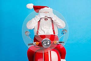 Photo of excited santa claus ride scooter x-mas magic surprise christmas stylish modern party close cover hands eyes