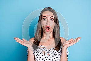 Photo of excited young girl open palms mouth shocked face wear dotted blouse isolated blue color background