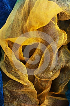 Photo of fabric dyed yellow and blue colors and laid out in an abstract form for use as a background