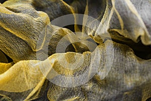 Photo of fabric dyed yellow color and laid out in an abstract form for use as a background