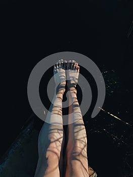 Photo of the feet of girl. She stand on a beautiful surface. View from above. Vertical shot