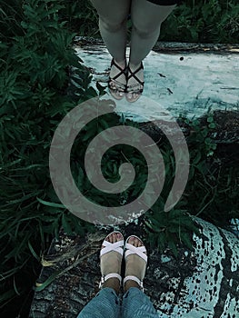 Photo of the feet of two girls. They stand on a beautiful surface. View from above. Vertical shot.