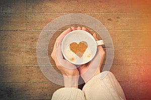 Photo of female hands holding cup of coffee on the wonderful bro