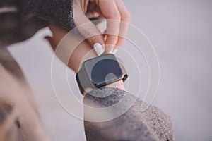 Photo of female hands touching setting of smart watch