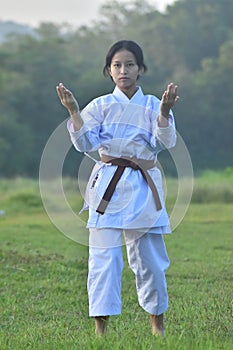 Photo of a female karate fighter in martial art costume pose an action move. photo