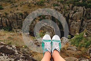 Photo female legs in gumshoes on the background of canyon