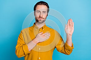 Photo of focused successful guy palm chest raise hand pledge vow wear yellow shirt isolated blue color background