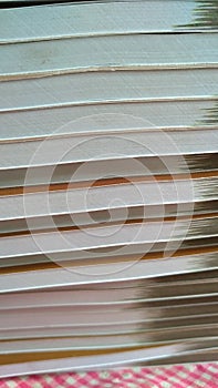 photo focusing on stack of books on pink background