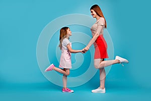 Photo of foxy little lady and mom holding hands looking eyes wear casual clothes isolated blue background