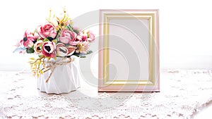 Photo frame with artificial flower pink rose on white background