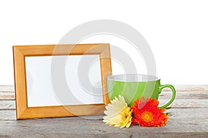 Photo frame with cup of coffee and gerbera flowers