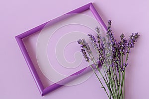 Photo frame with a lavender bouquet on a pastel background, top view, place for the inscription
