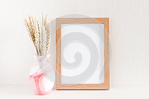 Photo frame mock up, bouquet of dry wheat spikelets in pink vase