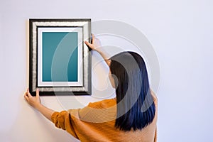 Photo Frame Mockup with Clipping Path. Woman Decorating a New Ho