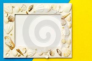 Photo frame with shells on blue and yellow color paper texture b