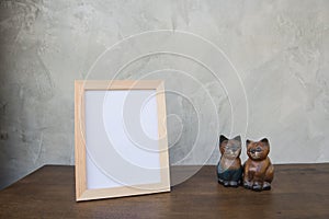 Photo Frame and toy cat on a wooden on Gray wall background .