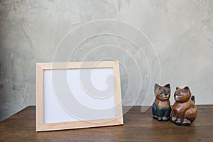 Photo Frame and toy cat on a wooden on Gray wall background .