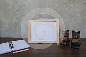 Photo Frame on a wooden table and book and toy cat