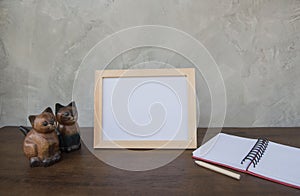 Photo Frame on a wooden table and book and toy cat