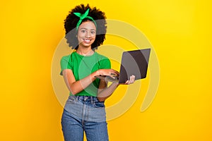 Photo of friendly cute girl toothy smile hold use wireless netbook elearning  on yellow color background