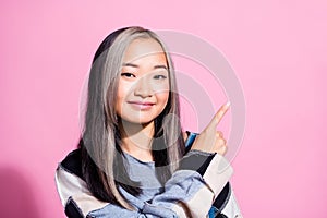 Photo of friendly lovely girl indicate finger empty space ad blank novelty isolated on pink color background