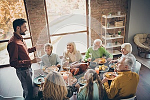 Photo of full big family gathering sit feast meals dinner table father guy telling thanksgiving pray toast multi