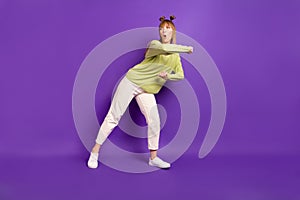 Photo of funky adorable young lady wear green sweater dancing looking empty space copyspace isolated violet color