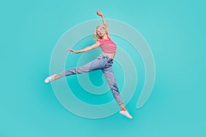 Photo of funky adorable young woman dressed red t-shirt smiling jumping high isolated teal color background
