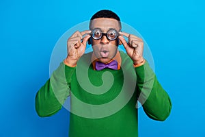 Photo of funky childish student nerd guy wear green jumper purple bowtie touch glasses pouted lips surprised isolated on