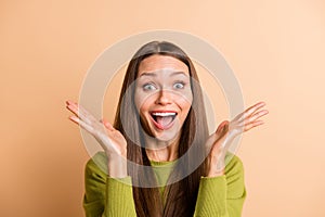 Photo of funky crazy young lady palms face open mouth wear green pullover isolated beige color background