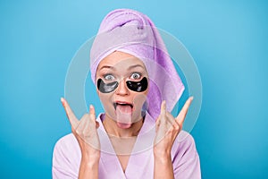 Photo of funky funny girl tongue-out show horns wear violet towel turban bath robe isolated blue color background