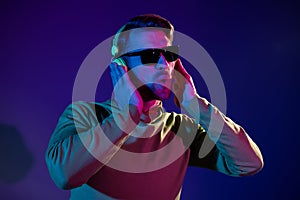 Photo of funky funny young man wear headphones sunglass clubber night life isolated on neon background