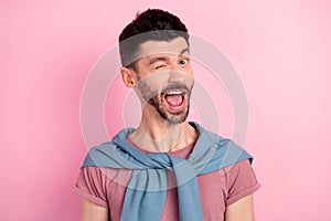 Photo of funky happy young man wink good mood wear blue jumper shoulders isolated on pink color background