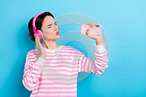 Photo of funky pretty girl closed eyes singing favorite song use phone as mic isolated on blue color background