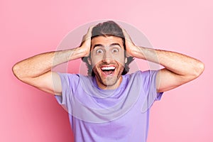 Photo of funny amazed guy hands head open mouth wear violet t-shirt isolated pastel pink color background