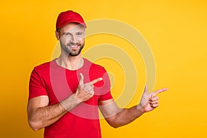 Photo of funny bearded guy indicate forefingers empty space wear red t-shirt cap isolated yellow color background