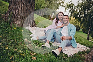 Photo of funny charming young wife husband dressed pastel shirts sitting plaid blanket enjoying sunshine outdoors