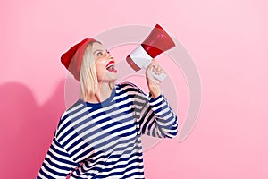 Photo of funny cheerful lady wear striped shirt shouting loudspeaker empty space isolated pink color background