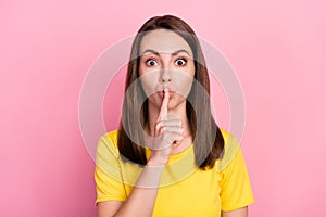 Photo of funny confident young woman dressed yellow t-shirt finger mouth asking keep silence isolated pink color