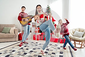Photo of funny cool big family wear christmas sweaters dancing showing hard rock signs smiling indoors room home house