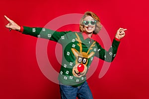 Photo of funny cute young guy dressed print pullover glasses dancing pointing fingers smiling isolated red color