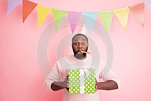 Photo of funny dark skin guy visit family meeting mother birthday noisemaker in mouth hold big giftbox wear sweater