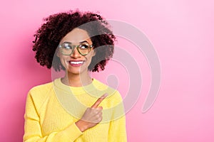 Photo of funny dreamy woman dressed kitted pullover glasses pointing looking empty space isolated pink color background