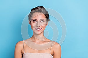 Photo of funny dreamy young woman dressed beige top looking empty space smiling  blue color background