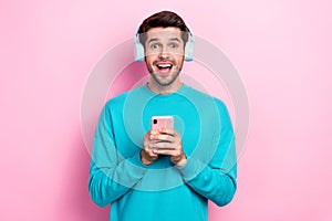 Photo of funny excited young man overjoyed shocked cheap itunes subscription hold phone listen headphones isolated on photo