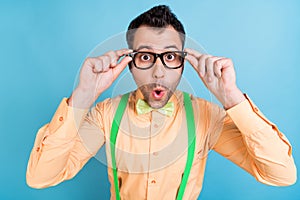 Photo of funny guy omg reaction wear spectacles green suspenders shirt bow tie isolated blue color background