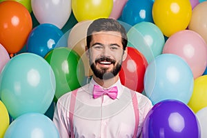 Photo of funny handsome gentleman guy surrounded colorful balloons arranging birthday party wear pink shirt bow tie