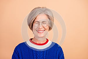 Photo of funny hilarious pensioner woman with gray hair dressed knitwear sweater in glasses laughing isolated on beige