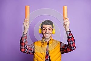 Photo of funny man aircraft marshaller wear yellow sleeveless jacket earphones eyewear holding lights isolated violet